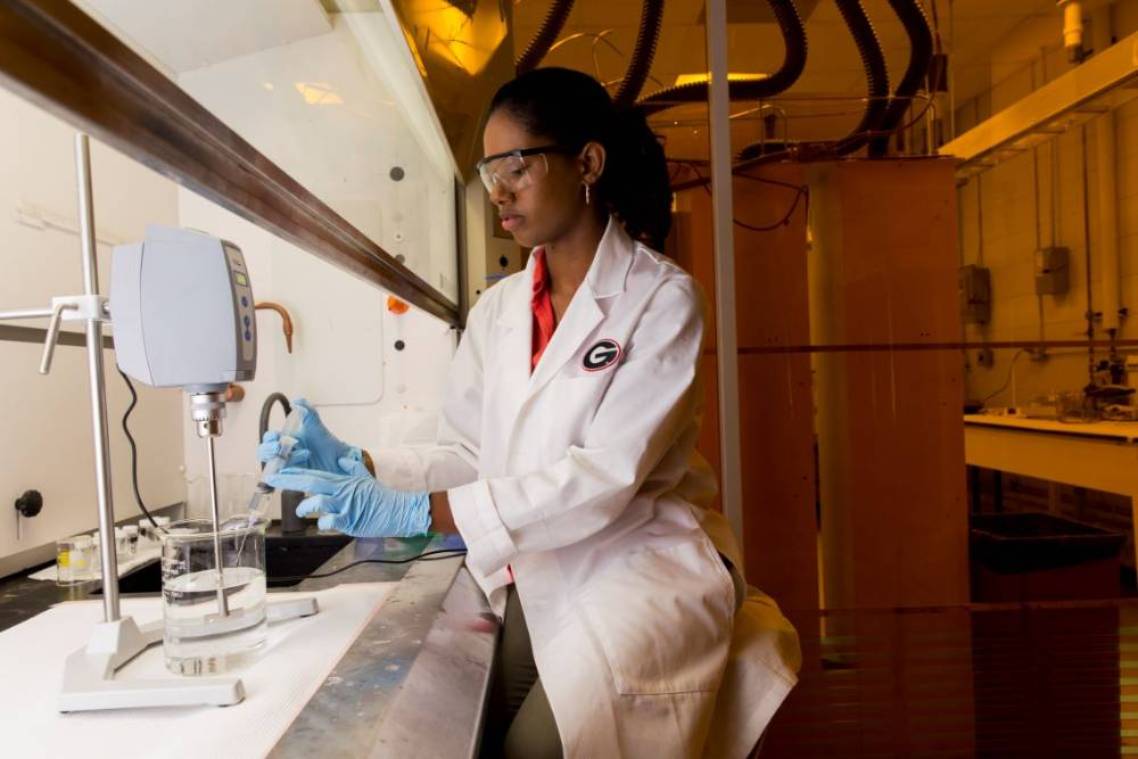 Female student working at a fume hood in Dr. Cheryl Gomillion's UGA lab